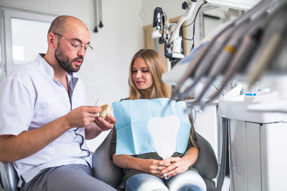 implantolog tłumaczy pacjentce co może jeść po wszczepieniu implanta zęba